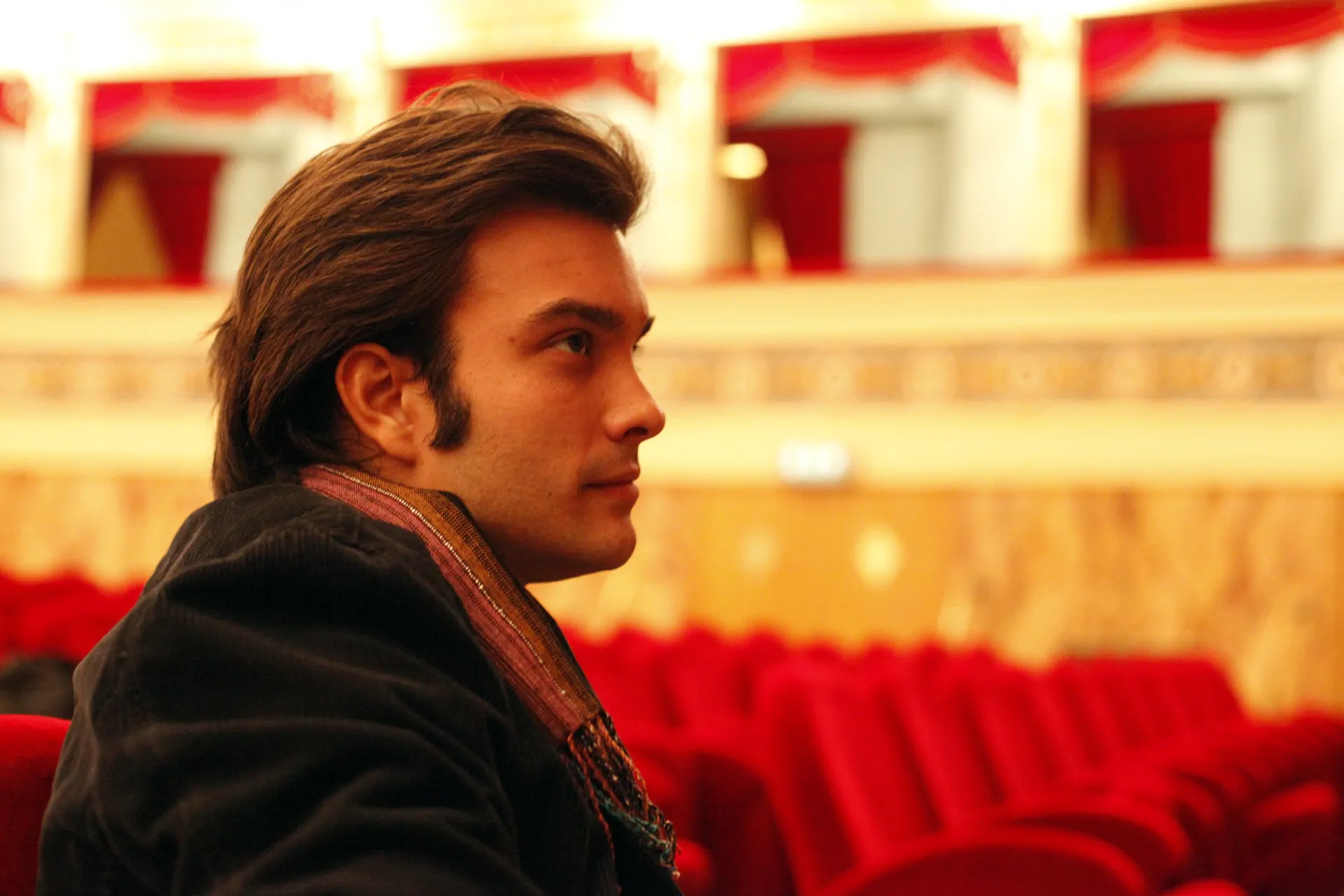 Hypnotist and stage director Lev Pugliese sitting in a red velvet parterre's armchair of an Opera House